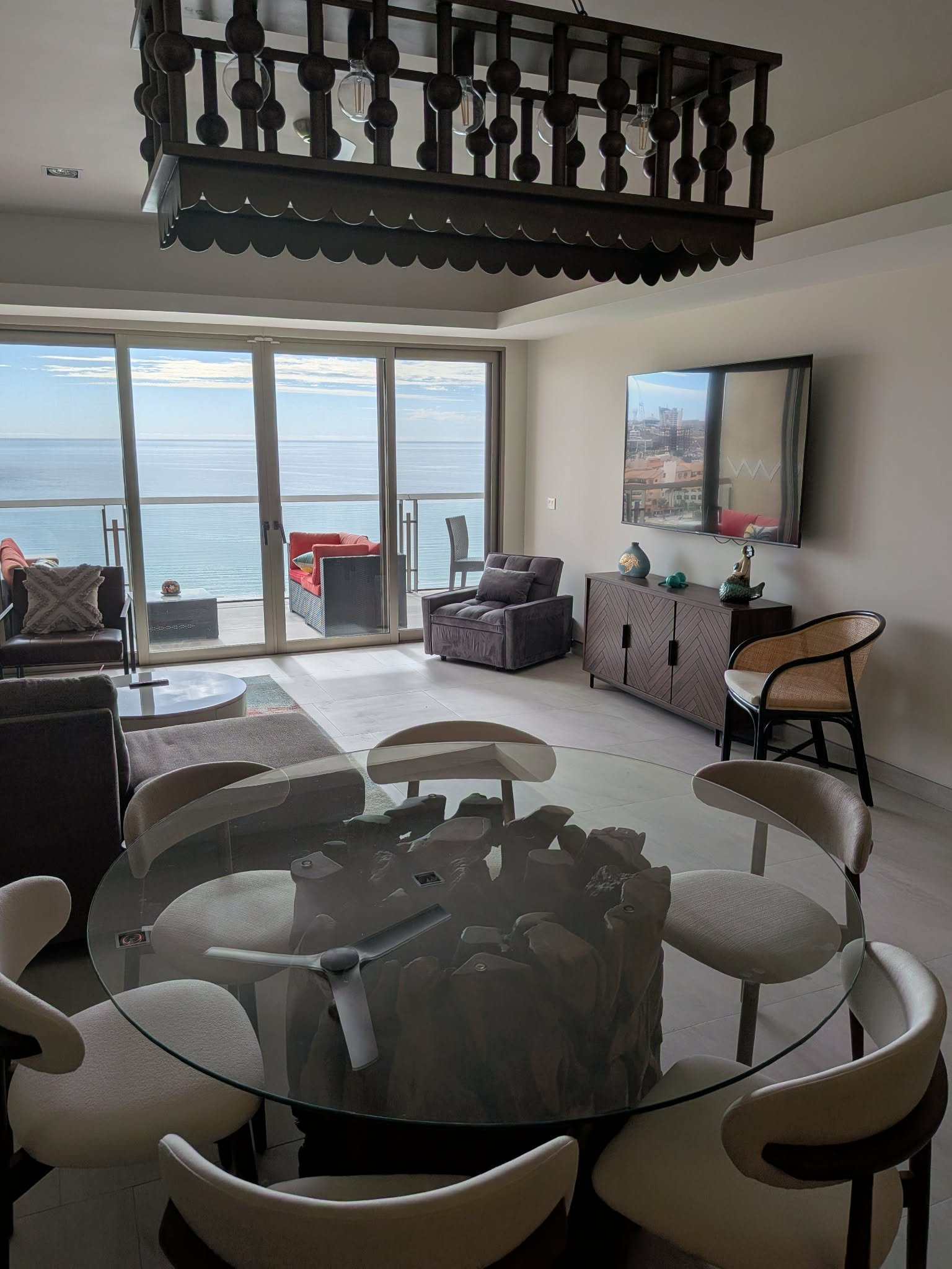 Condo living and dining room with wide ocean views through glass doors